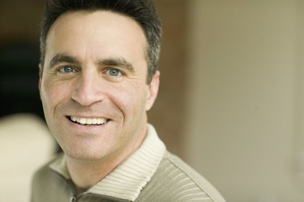 <p>A middle-aged man wearing an earth-tone sweater.</p>
